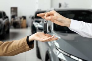 A person comparing options while looking at used and new cars in a dealership lot.