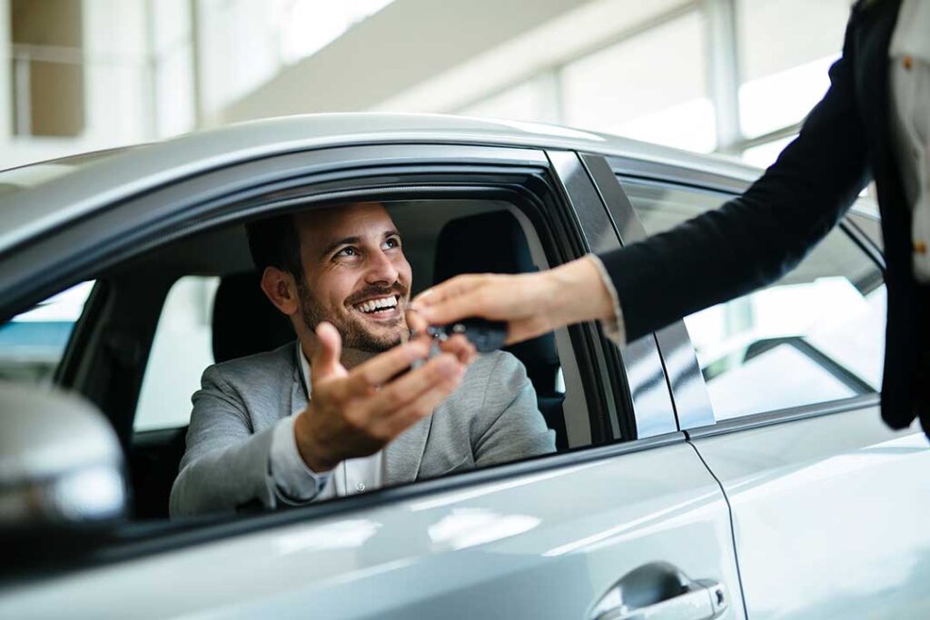 Driver reviews maintenance records beside a clean vehicle prepared for a trade-in appraisal.