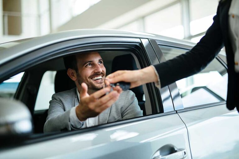 Driver reviews maintenance records beside a clean vehicle prepared for a trade-in appraisal.
